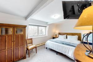 - une chambre avec un lit, un bureau et une télévision dans l'établissement Shredders and Hikers Delight Full Property, à Vail