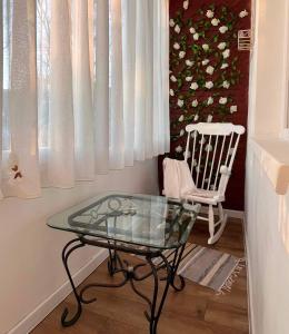 a glass table and a chair in a room at Niran Apartament in Oradea