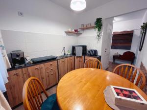 a kitchen with a wooden table and a kitchen counter at Niran Apartament in Oradea