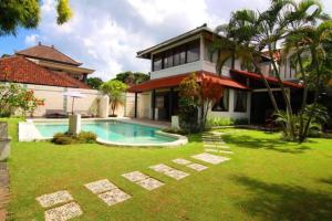 a house with a swimming pool in the yard at White Moon - Dream 5br Villa in Legian close to the Beach in Kuta