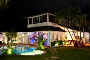 a house with a swimming pool at night at White Moon - Dream 5br Villa in Legian close to the Beach in Kuta