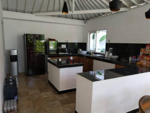 a kitchen with black and white counters and a fish tank at White Moon - Dream 5br Villa in Legian close to the Beach in Kuta