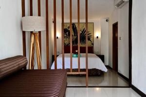 a bedroom with a bed and a couch and a mirror at White Moon - Dream 5br Villa in Legian close to the Beach in Kuta +39 photos