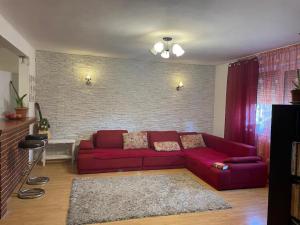 sala de estar con sofá rojo y pared de ladrillo en Casa Mangalia, en Mangalia