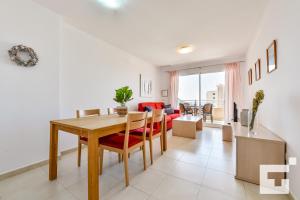 a dining room and living room with a table and chairs at Apartamento Apolo XIX 34L - Grupo Turis in Calpe