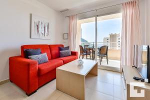 sala de estar con sofá rojo y mesa en Apartamento Apolo XIX 34L - Grupo Turis, en Calpe