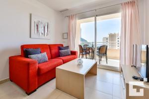 a living room with a red couch and a table at Apartamento Apolo XIX 34L - Grupo Turis in Calpe