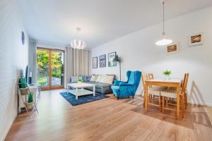 a living room with a table and blue chairs at Apartamenty Sun & Snow Aquarius in Sopot