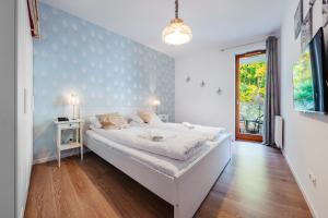 a bedroom with a large white bed in a room at Apartamenty Sun & Snow Aquarius in Sopot