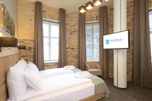 a bedroom with a white bed with a sign on it at Wellton Centrum Hotel & SPA in Riga
