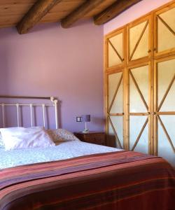 1 dormitorio con 1 cama y puerta de madera grande en CASA RURAL LA TI ISABEL, en Folgoso de la Carballeda