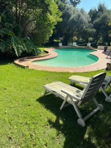 a table and a chair next to a swimming pool at Secured cottage in equestrian estate - LOADSHEDDING FREE! in Midrand