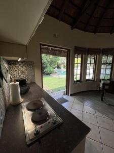 a kitchen with a stove and a counter top at Secured cottage in equestrian estate - LOADSHEDDING FREE! in Midrand