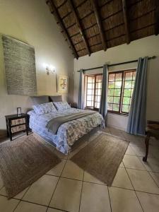 1 dormitorio con 1 cama en una habitación con ventanas en Secured cottage in equestrian estate - LOADSHEDDING FREE! en Midrand