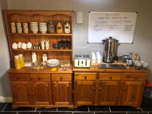 a kitchen with wooden cabinets and a counter with a mixer at Old School B & B in Llandysul