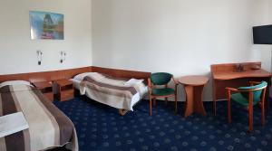 um quarto com duas camas e uma mesa e cadeiras em Hotel Alicja em Lódź
