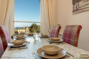 a table with chairs and bowls and plates on it at Seascape in North Berwick +26 photos