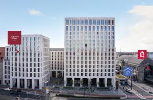 two tall white buildings in a city at Leonardo Royal Hotel Nürnberg in Nuremberg