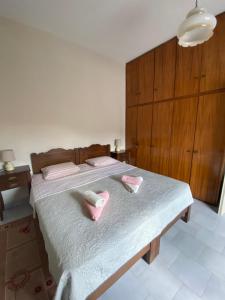 um quarto com uma cama com chinelos cor-de-rosa em Casa Helen em Limín Iérakos