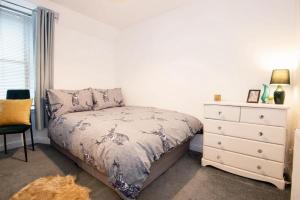 a small bedroom with a bed and a dresser at Unique 2 Bedroom Flat Kirrie Scotland in Kirriemuir
