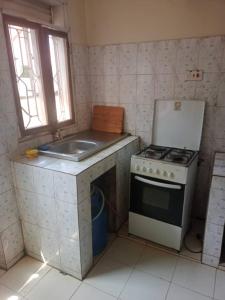 a small kitchen with a stove and a sink at Abid's Homestay in Kampala