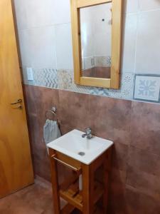 y baño con lavabo y espejo. en Cabañas El Fogón en Potrerillos