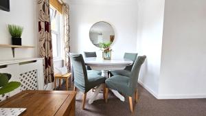 ein Esszimmer mit einem Tisch, Stühlen und einem Spiegel in der Unterkunft 2 bed apt w/ private parking close to town centre in Huntingdon