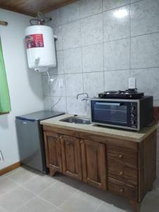 a kitchen with a sink and a microwave on a counter at Departamento El Renuevo in Vista Flores