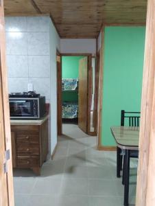 a kitchen with a microwave on a counter and a table at Departamento El Renuevo in Vista Flores