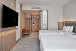ein Hotelzimmer mit zwei Betten und einem Flachbildfernseher in der Unterkunft Courtyard by Marriott Berlin City Center in Berlin