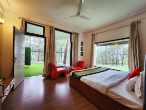 a bedroom with a bed and a large window at Hotel Bliss in Kasauli