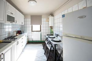 a kitchen with white cabinets and a table in it at Apartament S46 in Roman