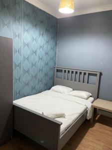 ロンドンにある03 Bedroom Apartment-Self Check inの青い壁のドミトリールームのベッド1台分です。