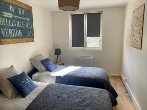 ein Schlafzimmer mit 2 Betten und ein Schild an der Wand in der Unterkunft Le Biclou- 3 chambres in Bazincourt-sur-Saulx