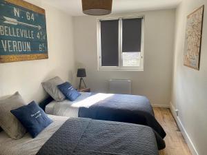 sypialnia z 2 łóżkami i znakiem na ścianie w obiekcie Le Biclou- 3 chambres w mieście Bazincourt-sur-Saulx +4 zdjęcia