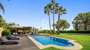 a villa with a swimming pool and palm trees at Villa Maracana in Marbella