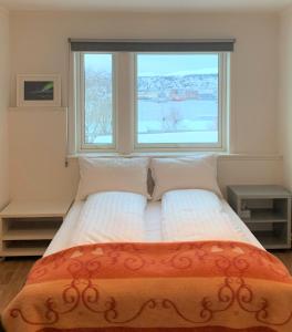 a bed in a room with a large window at Villa top view Tromsø in Tromsø