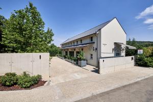 a white building with a fence in front of it at La Maison 