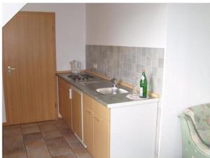 eine Küche mit einem Waschbecken und einer Flasche Wein in der Unterkunft Hotel Societät in Emmerich