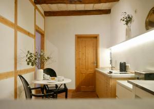 リューネブルクにあるStay Hygge - Zentrales Altstadt-Apartment in Lüneburg mit kostenfreiem Parkplatzのキッチン(テーブル、小さなテーブル、椅子付)