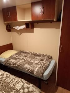 um pequeno quarto com uma cama e armários em Mobil-home camping 