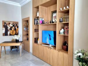 una sala de estar con una estantería con TV en Hotel Carlton Nice, en Niza