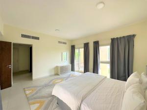 una camera con un grande letto e una finestra di Luxurious 3B Villa with Balcony in Ras Al Khaimah a Ras al Khaimah