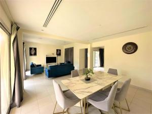 comedor y sala de estar con mesa y sillas en Luxurious 3B Villa with Balcony in Ras Al Khaimah, en Ras al Khaimah