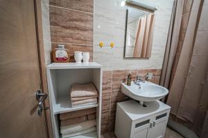 a bathroom with a sink and a toilet and a mirror at URBAN GREY APARTMAN in Sremska Mitrovica