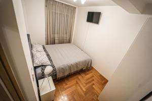 a small bedroom with a bed and a television at URBAN GREY APARTMAN in Sremska Mitrovica +10 photos