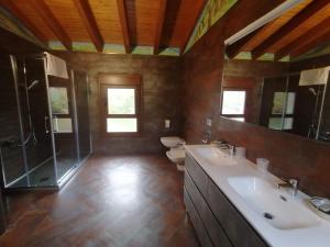 a bathroom with two sinks and a shower and a toilet at PENSIÓN RÚSTICA SANTA MARIÑA DA PONTE 