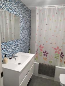 a bathroom with a sink and a shower curtain with flowers at Castellon Center Modern Spacious Apartment in Castellón de la Plana