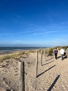 Vakantiewoning aan Zee - 150m van het Strand في إغموند آن زي: مجموعة من الناس يمشون على الشاطئ