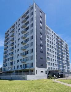 a large apartment building with a grass field in front of it at Santana Holiday Resort in Margate